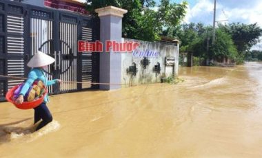 Người dân phải bám dây để về nhà vì nước chảy xiết
