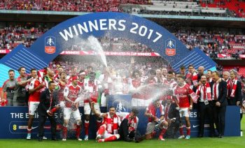 
Các cầu thủ Arsenal bật champagne ăn mừng tại bục chiến thắng
