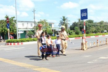 Cán bộ, chiến sĩ Cảnh sát giao thông Công an tỉnh Bình Phước giúp các các em học sinh qua đường Quốc lộ 14, khu vực xã Tân Thành, thị xã Đồng Xoài sau giờ tan trường 