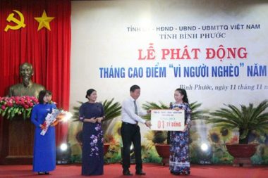 Chủ tịch Ủy ban MTTQ Việt Nam tỉnh Đồng Nai (Bìa trái) Đào Văn Phước trao bảng tượng trưng số tiền hỗ trợ 1 tỷ đồng cho tỉnh Bình Phước trong công tác giảm nghèo